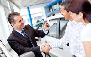 Family buying a car from a smiling dealer