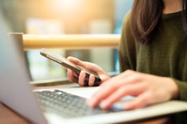 Woman on her laptop computer and phone simultaneously