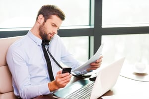 Worker surrounded by technology multi-tasking