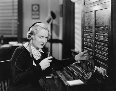 Woman operating a manual telephone switchboard