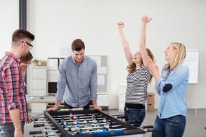 Employees playing foosball together