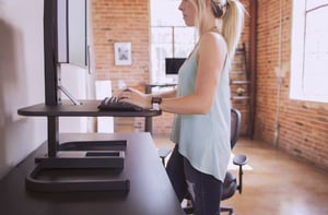 Woman in an urban office using a standing desk