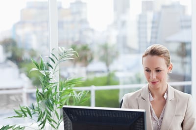 Businesswoman with a view and office plants receiving Slack digital reception notifications