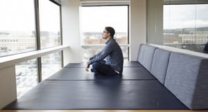 Man relaxing in a modern office meditation room