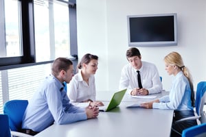 Business professionals in a conference room reviewing visitor data analytics