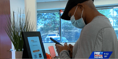 Guest using a contactless visitor management system to check out of a hybrid office