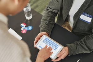Security manager checking in guest with visitor management software