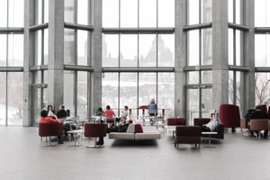 Employees using visitor management software in a hybrid office with large windows