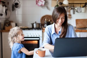 Child distracting her mom who is working from home in the kitchen
