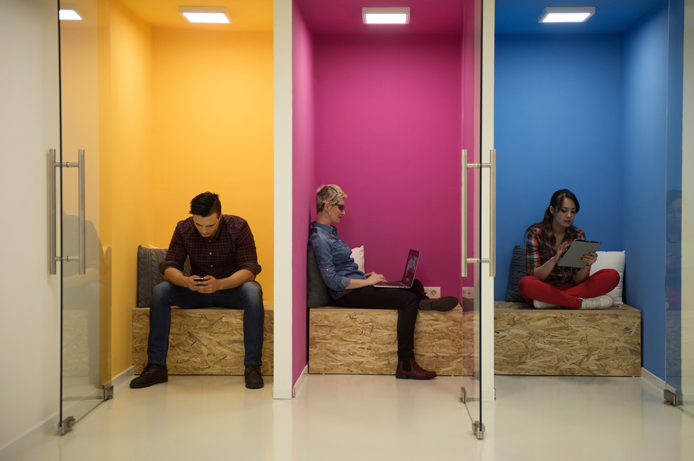 Flexible workspace members working in phone booths