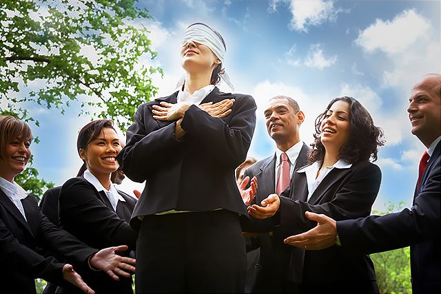 Lady in a suit about to do an employee trust fall
