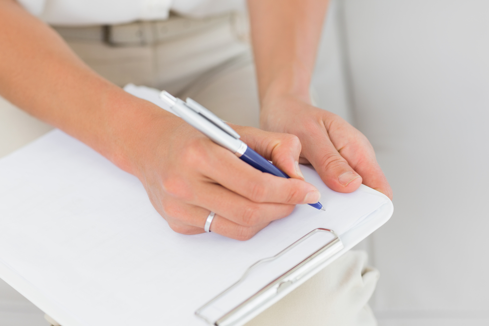 Signing into a paper visitor logbook