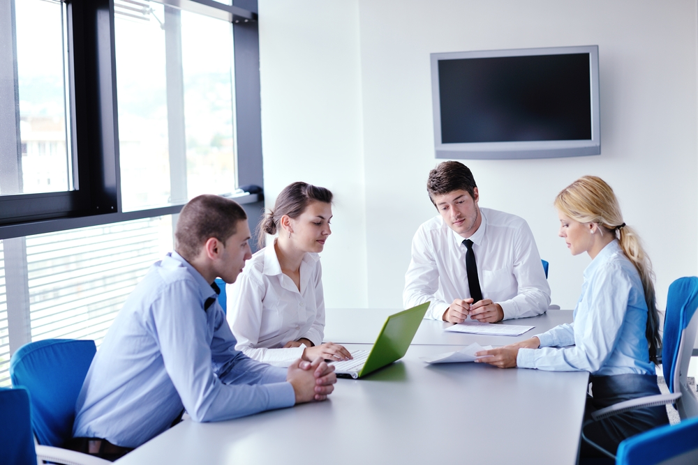 Business professionals in a conference room reviewing visitor data analytics