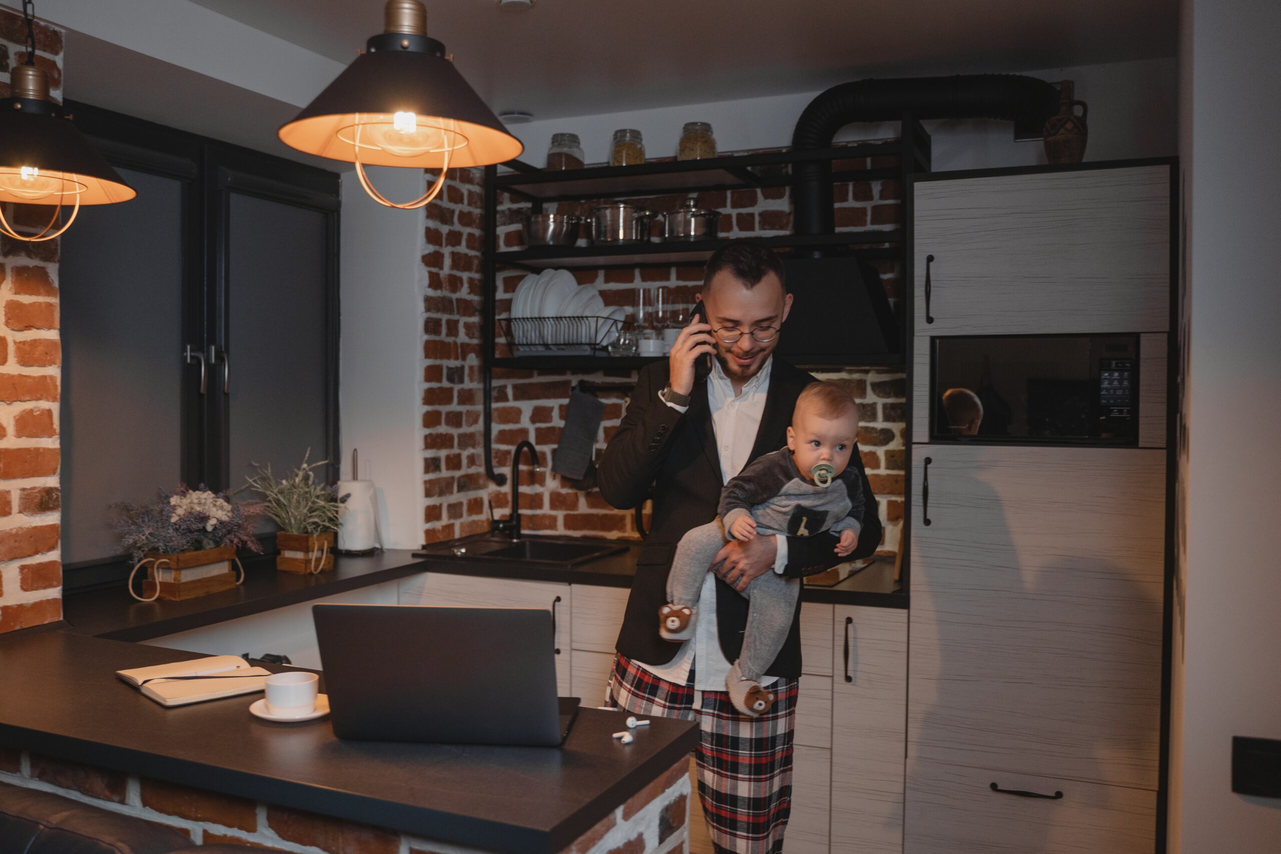 Tech employee works from home while holding a baby