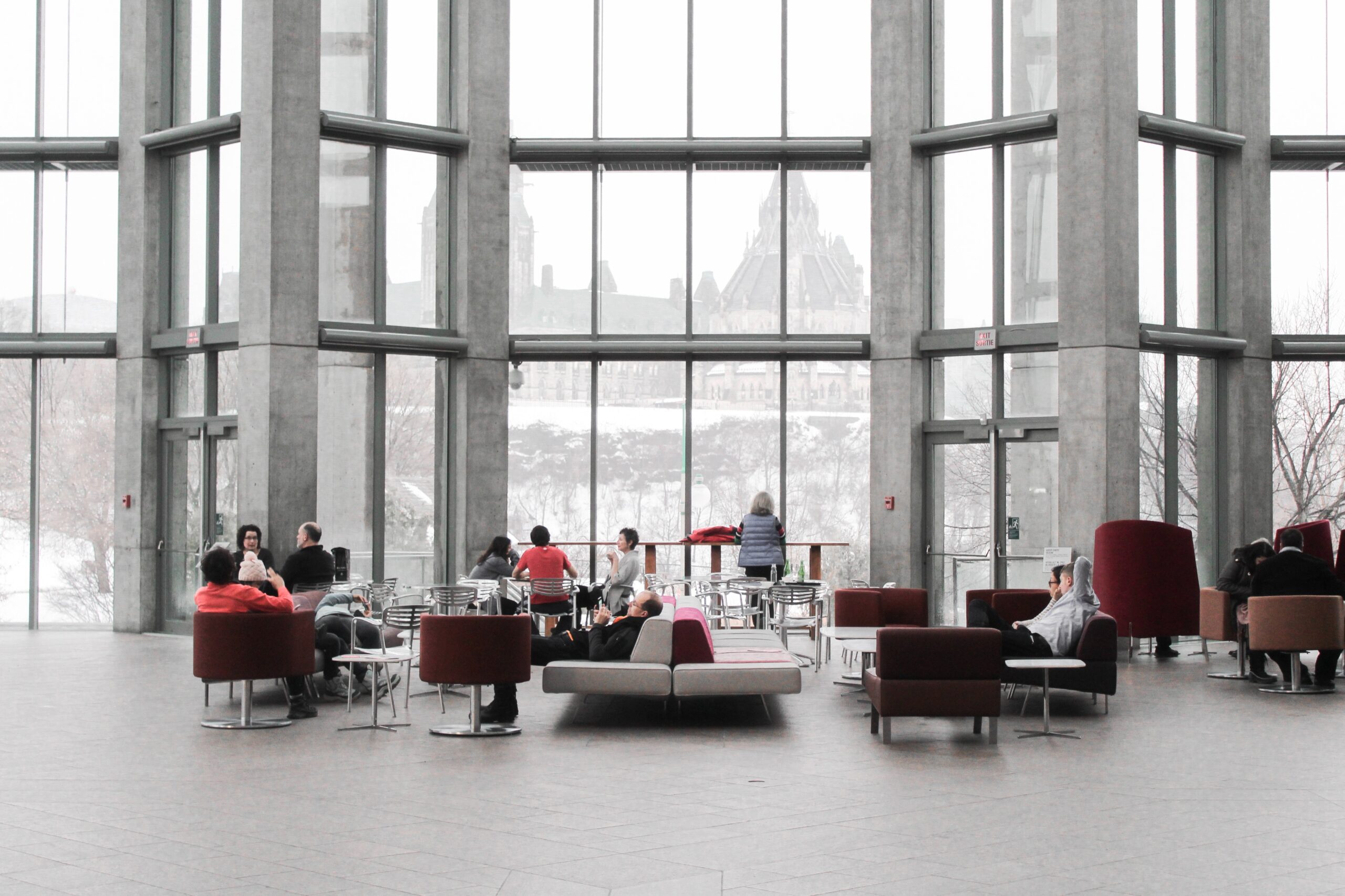 Employees using visitor management software in a hybrid office with large windows